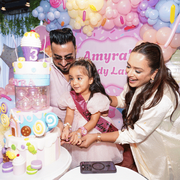 amily celebrating a child's birthday at Wooray Delhi with colourful balloon decorations.