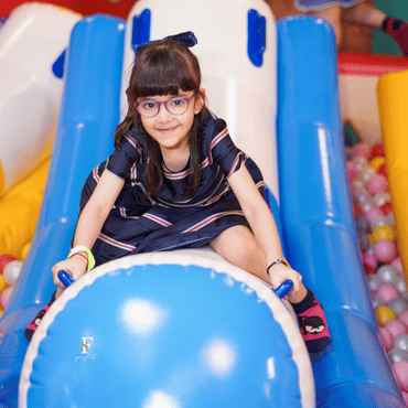 Girl enjoying an indoor slide at Wooray Delhi play area.