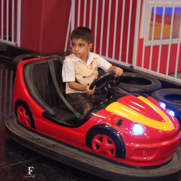 Child enjoying a bumper car ride at Wooray Delhi indoor play area.