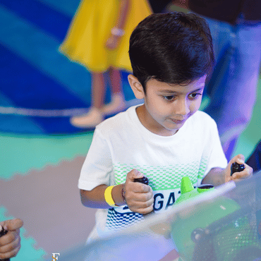 Child enjoying an interactive arcade game at Wooray Delhi.