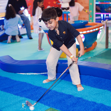 Child playing mini golf at Wooray Delhi indoor play area.
