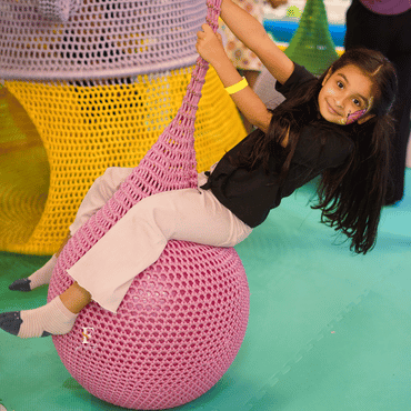 Girl enjoying a colourful net swing activity at Wooray Delhi.