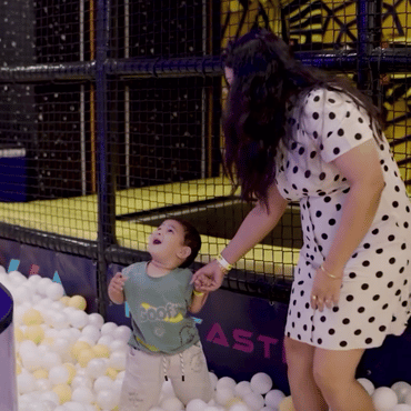 Child enjoying colourful ball pit play with an adult at Wooray Hyderabad.