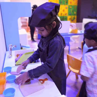 Girl playing an interactive space-themed wall game at Wooray Hyderabad.