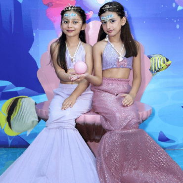 Two children dressed as mermaids enjoying an underwater-themed experience at Wooray Hyderabad.