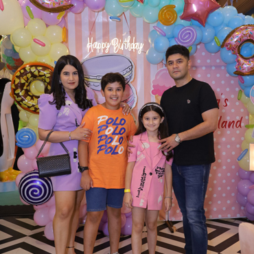 Family celebrating a child's birthday at Wooray Patna with colourful candy-themed decorations.