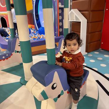 Toddler enjoying a fun rocking ride at Wooray Dehradun indoor play area.