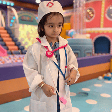 Child dressed as a doctor enjoying pretend play at Wooray Dehradun.