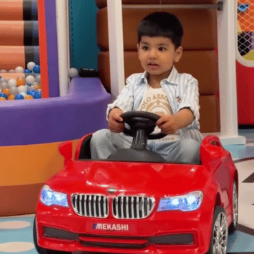 Child enjoying a red electric car ride at Wooray Dehradun indoor play area.