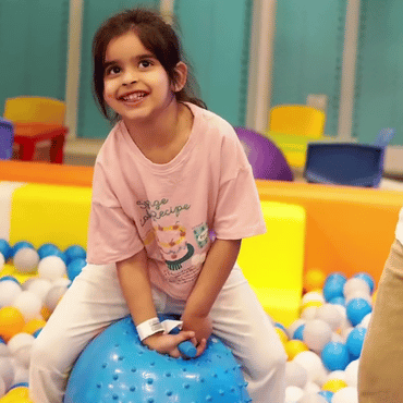 Girl enjoying a bouncy ball activity at Wooray Dehradun indoor play area.